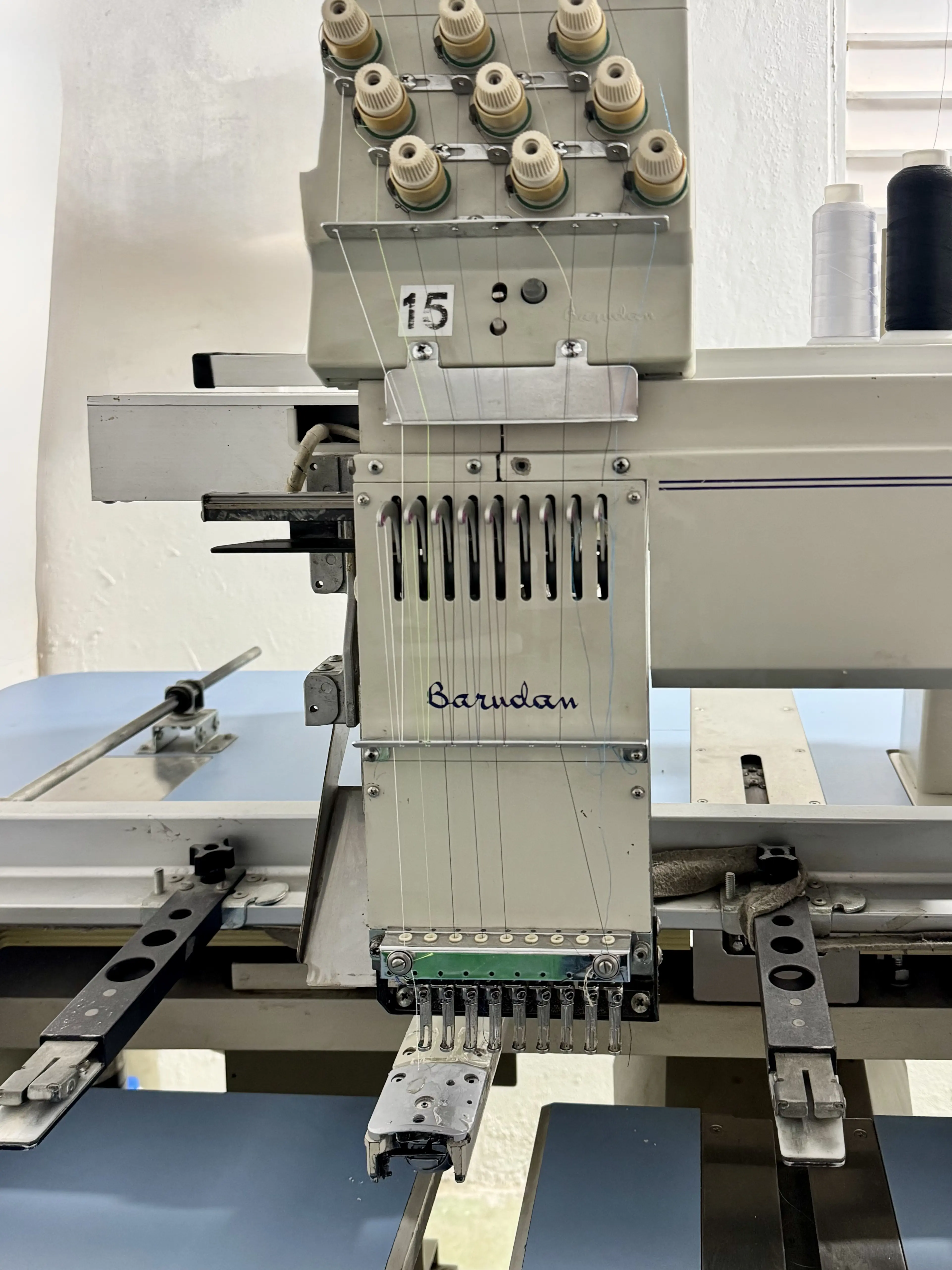 Detalle del cabezal de bordado Barudan con hilos y agujas de precision